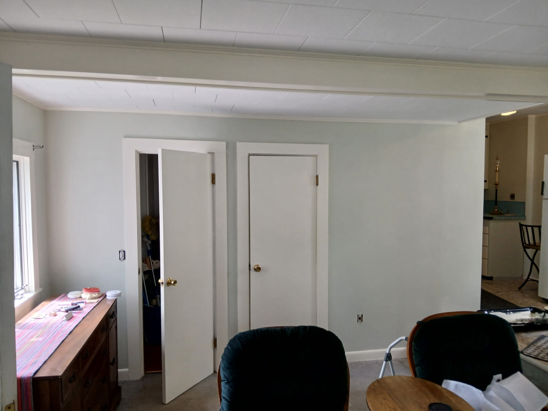 Open living and dining area with pale gray walls and white doors
