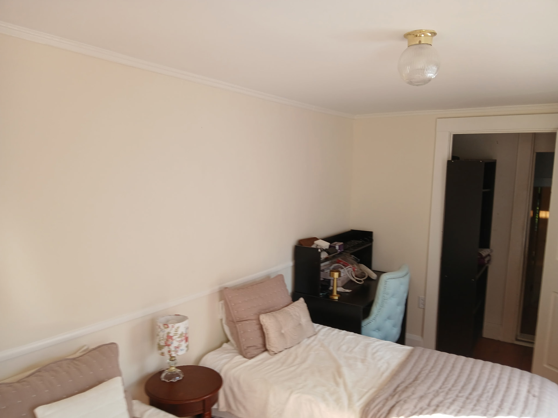 Bedroom with freshly painted warm cream walls and white chair rail